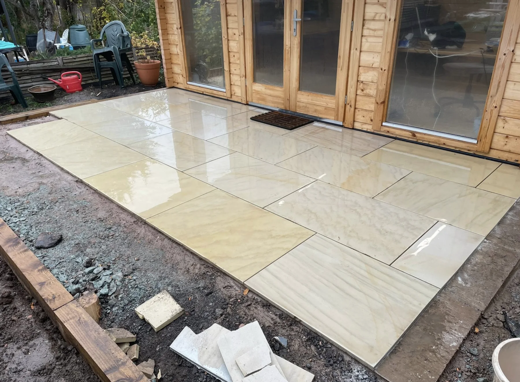 Large-format porcelain patio laid beside a timber garden room
