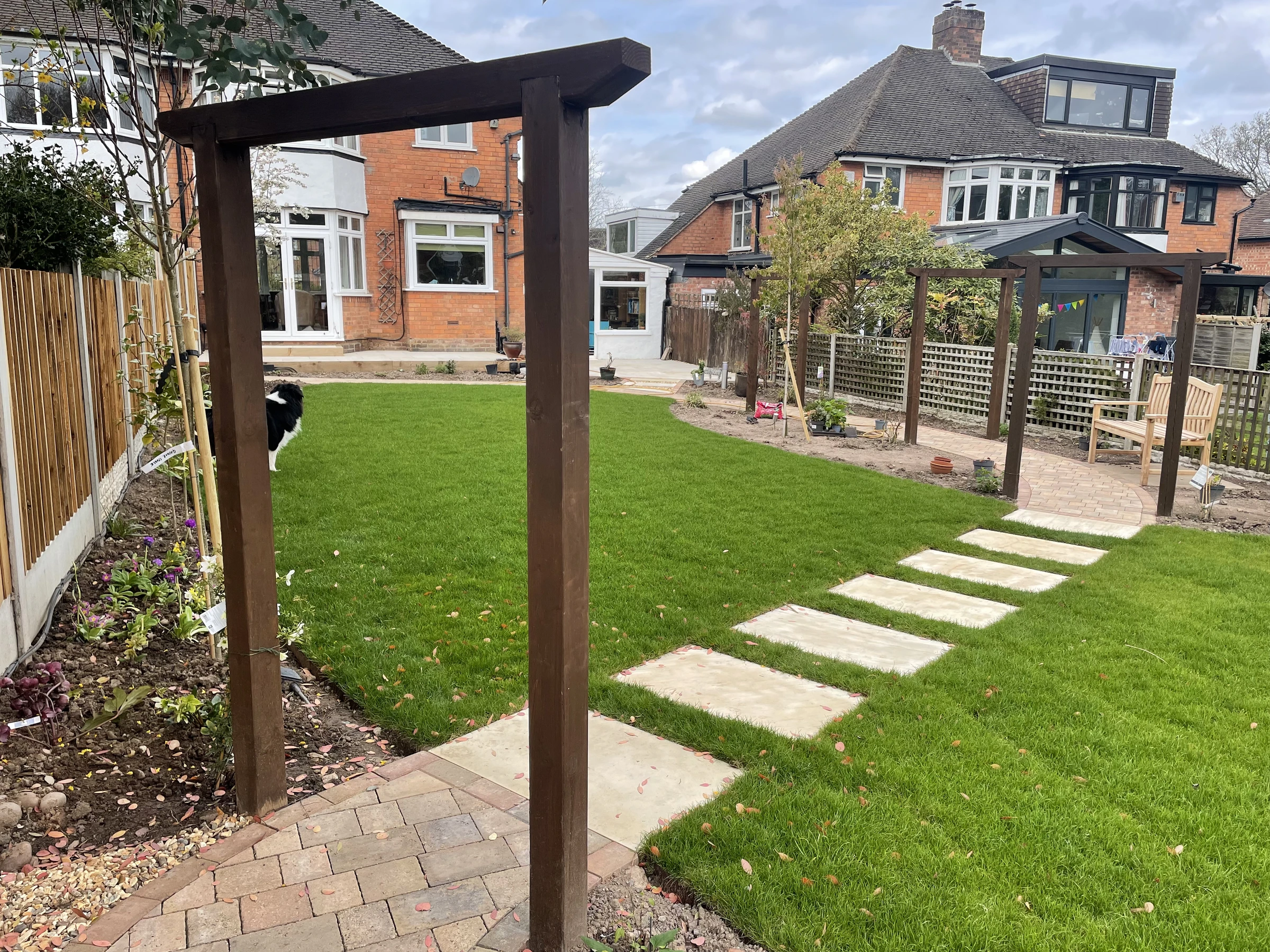 Landscaped garden with lawn, stepping stones and timber archways